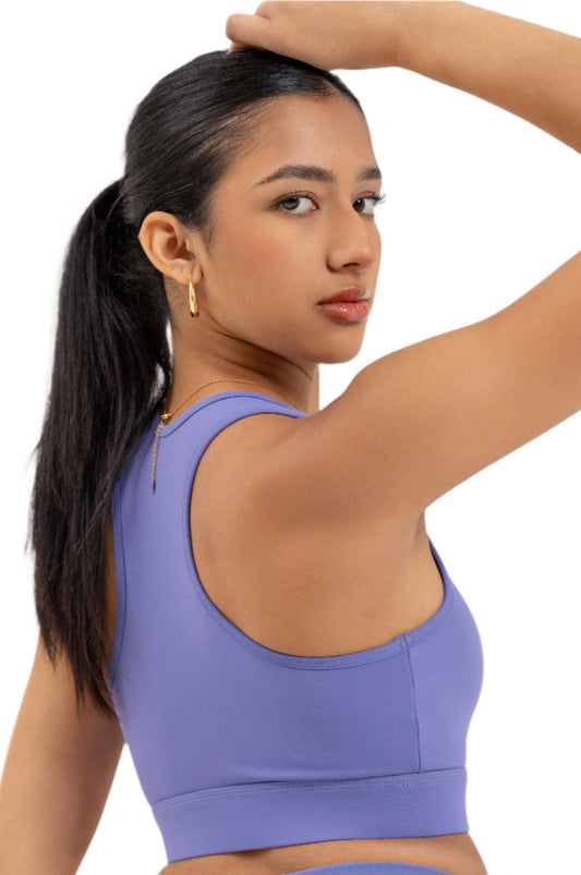 Close-up back view of woman wearing Myticos®️ lavender sports bra and leggings set, featuring waistband logo and racerback bra design.
