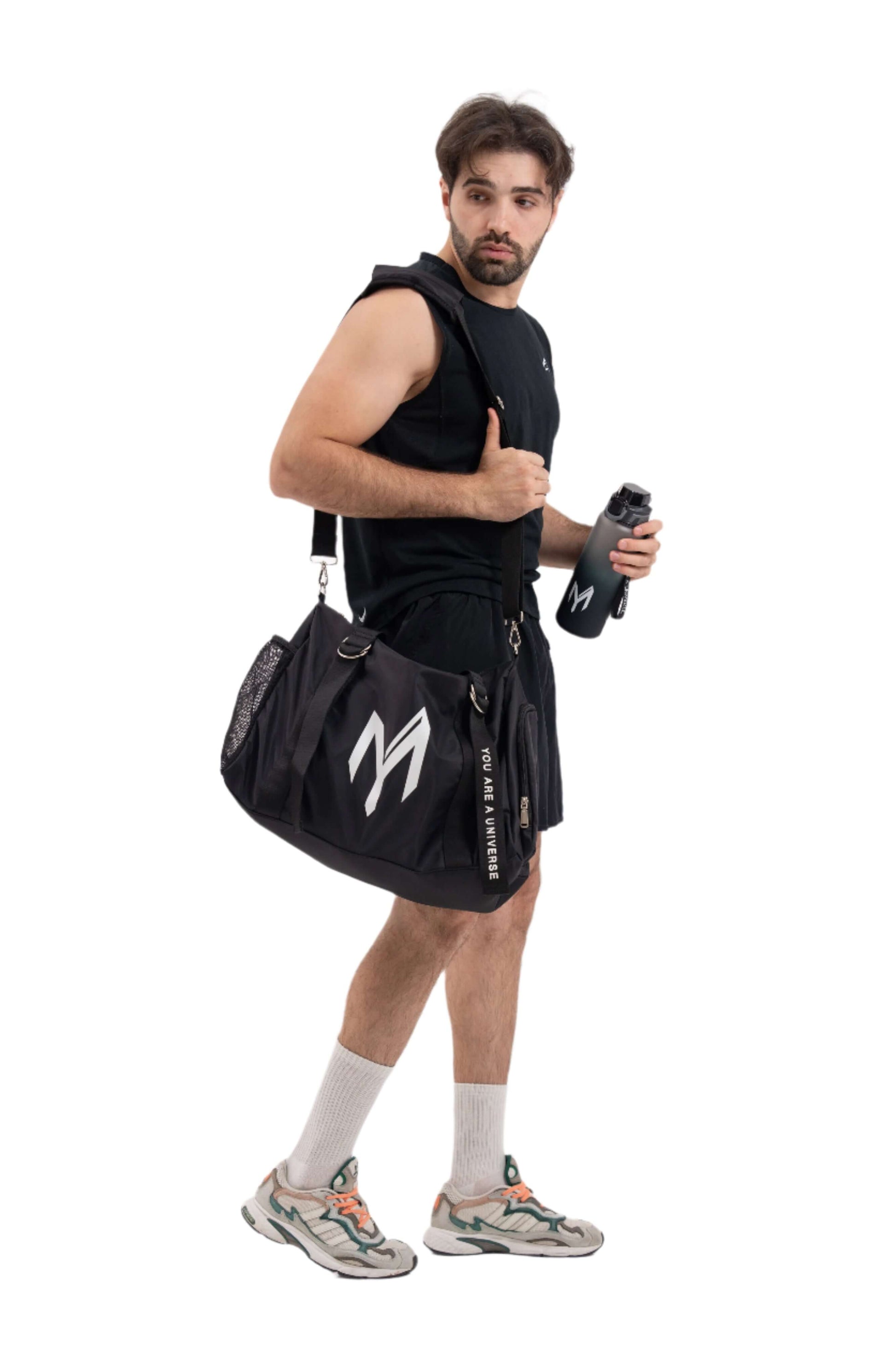 Man holding a black gym bag with a logo on a white background