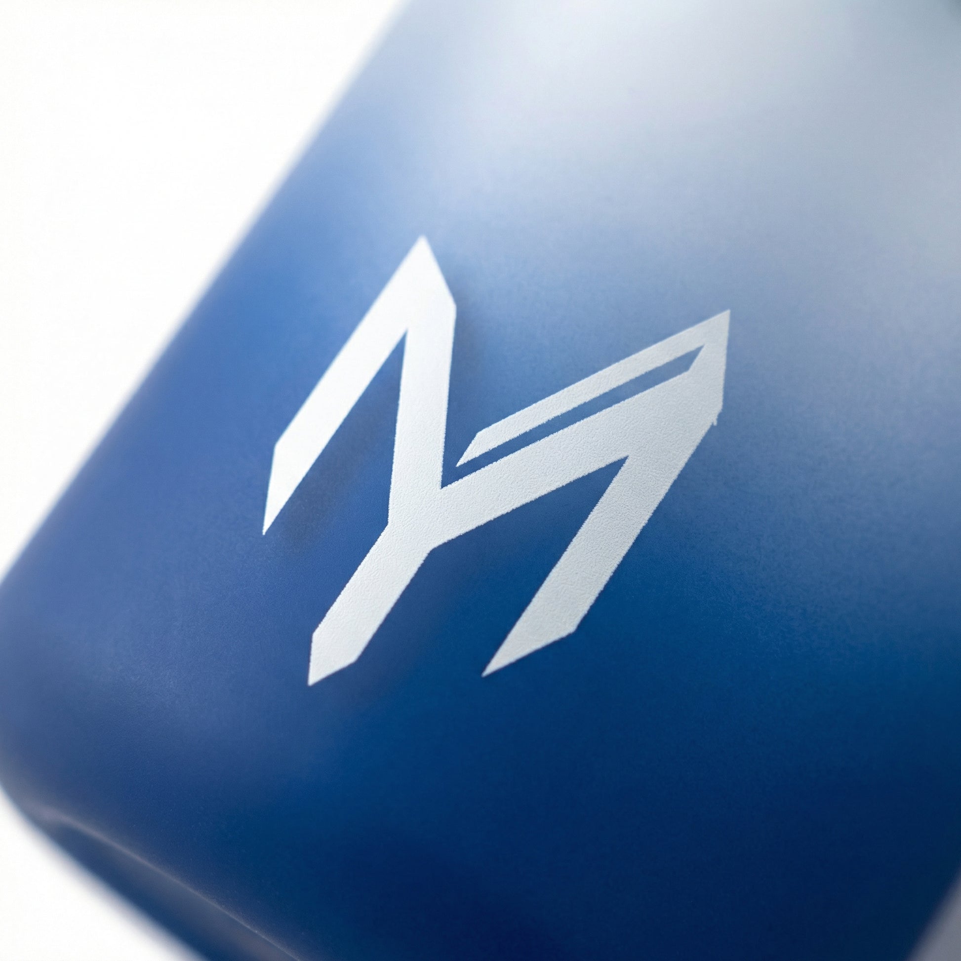 Myticos M monogram detail on blue bottle - studio macro