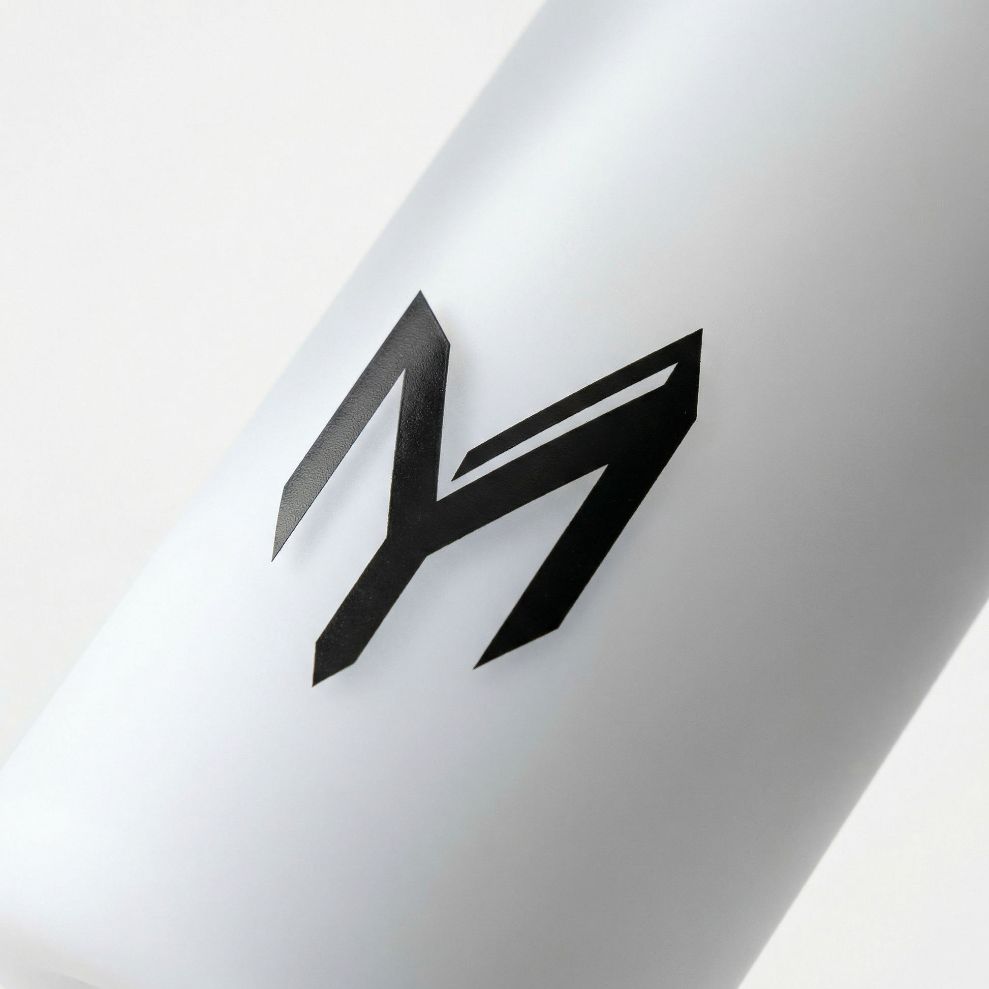 Myticos M monogram detail on white bottle - studio macro