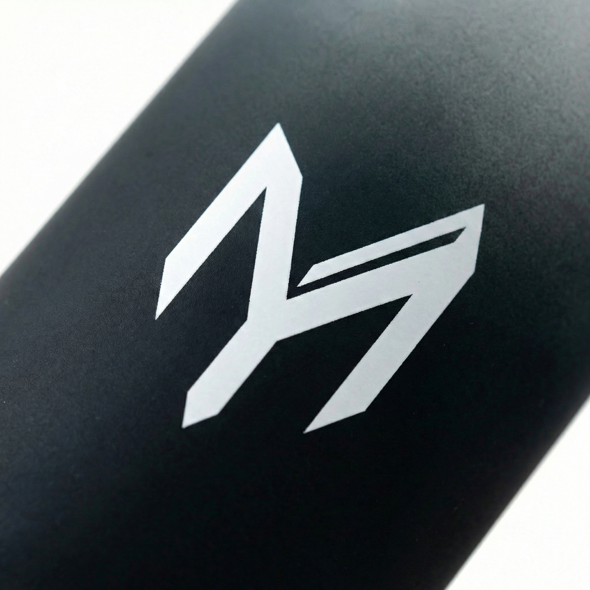 Myticos M monogram detail on black bottle - studio macro