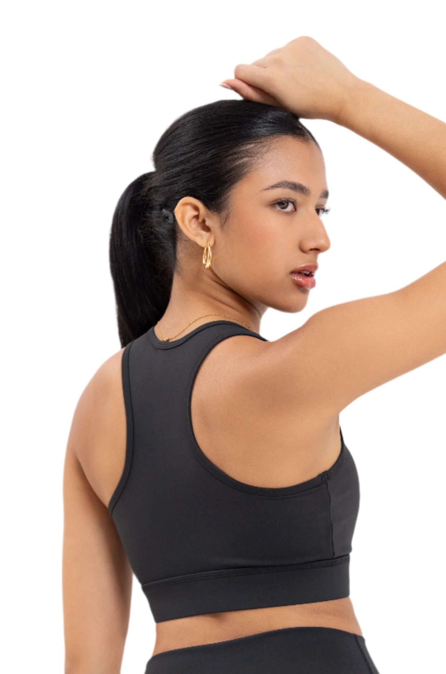 Back view of woman wearing Myticos®️ black sports bra and leggings set, highlighting waistband logo and racerback bra style against a white background.