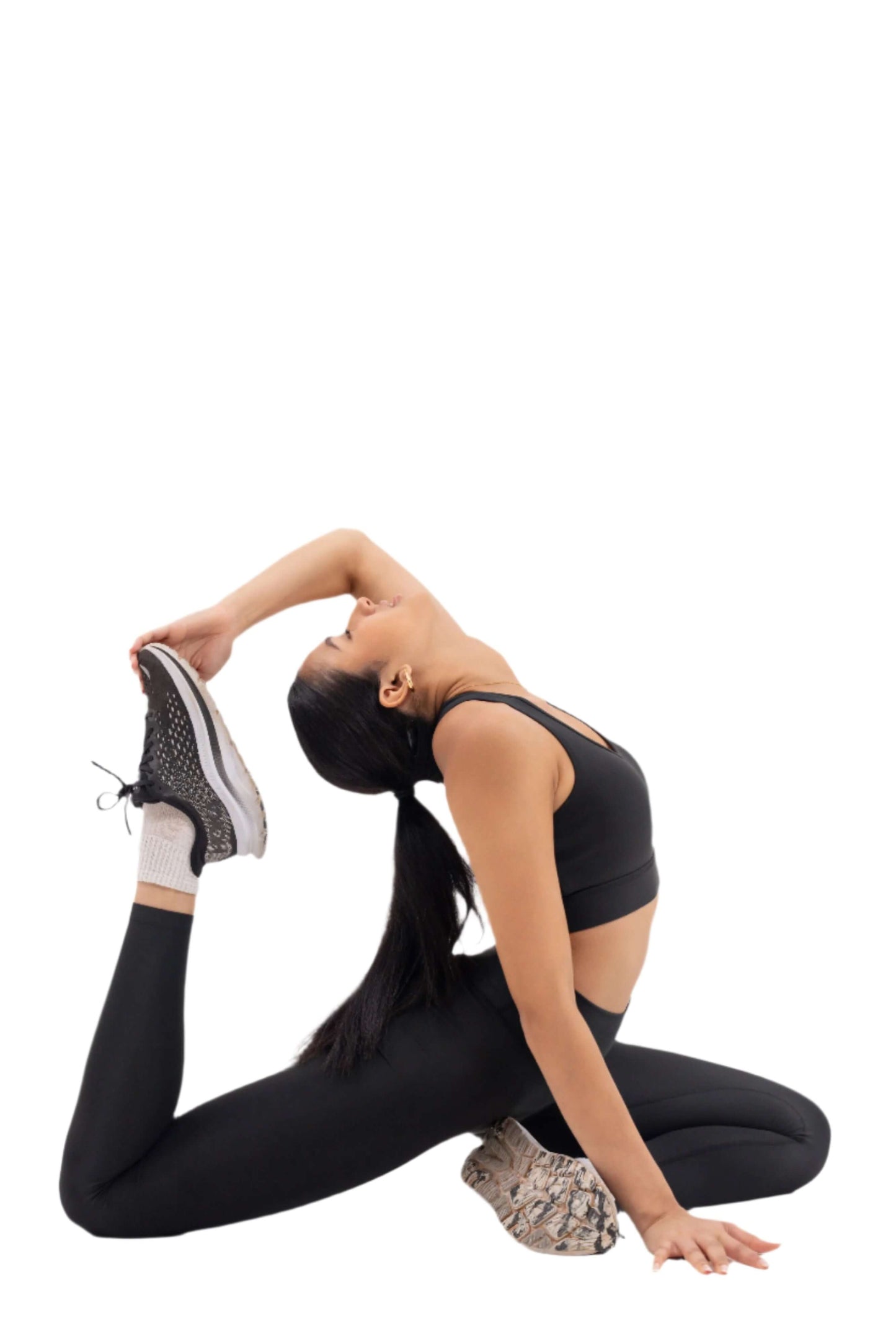 Woman performing a yoga pose wearing Myticos®️ black sports bra and leggings set, showcasing flexibility and comfort of the activewear against a white background.
