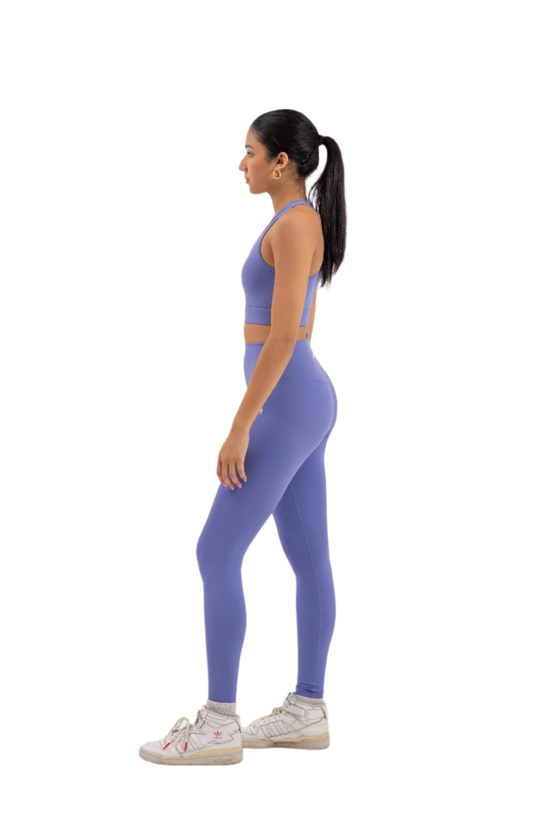 Front view of woman wearing Myticos®️ lavender sports bra and leggings set, showcasing sleek design and supportive fit against a white background.