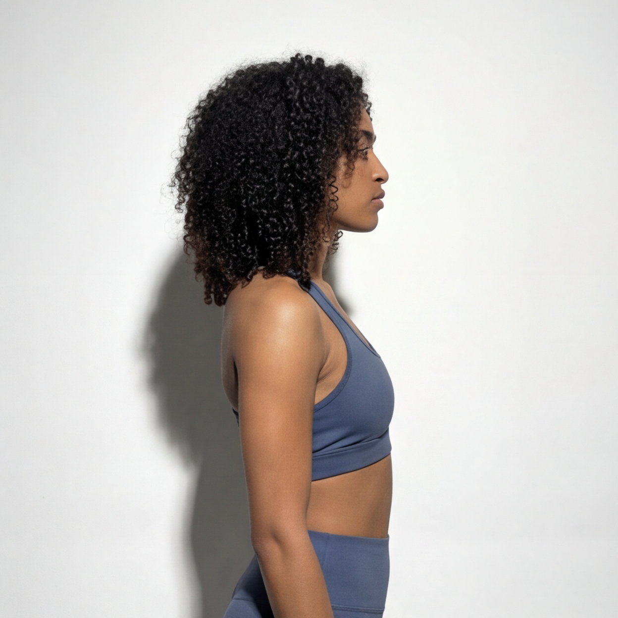 Woman wearing a blue athletic outfit against a white background